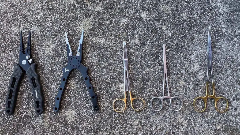 Different types of fishing pliers on the floor