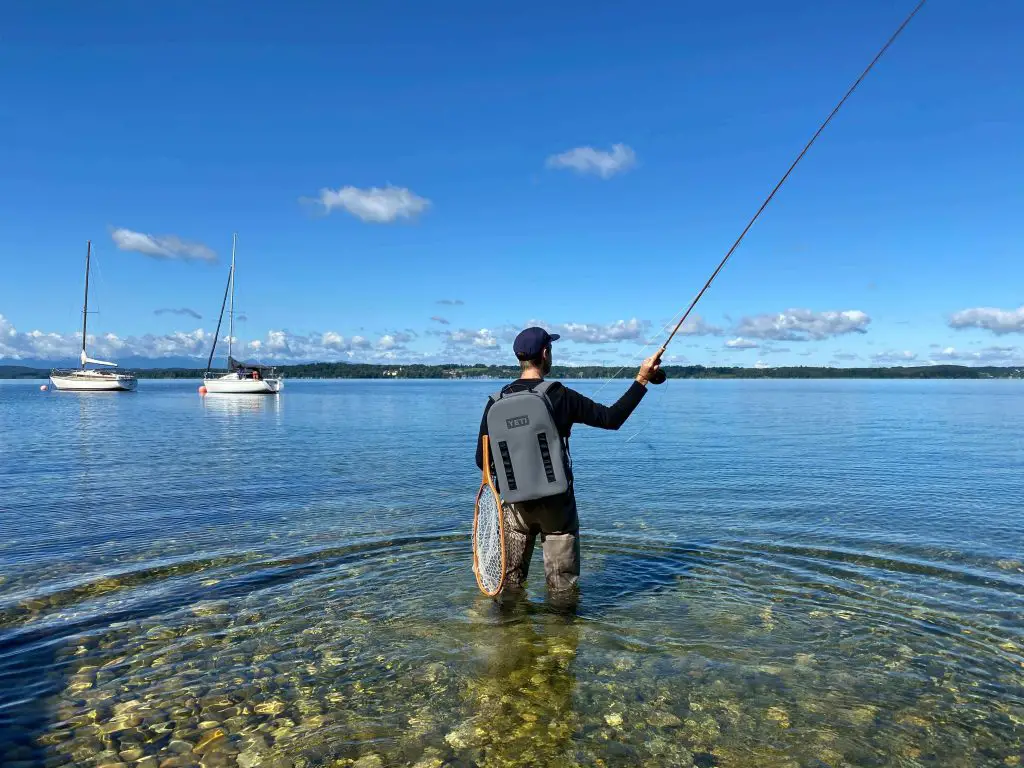 Fly fisherman in water wearing the best fly fishing backpack