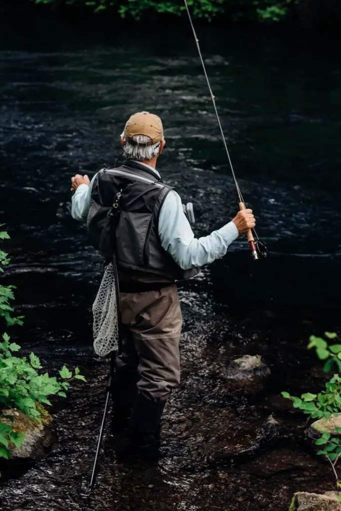 A fly fisherman standing a river