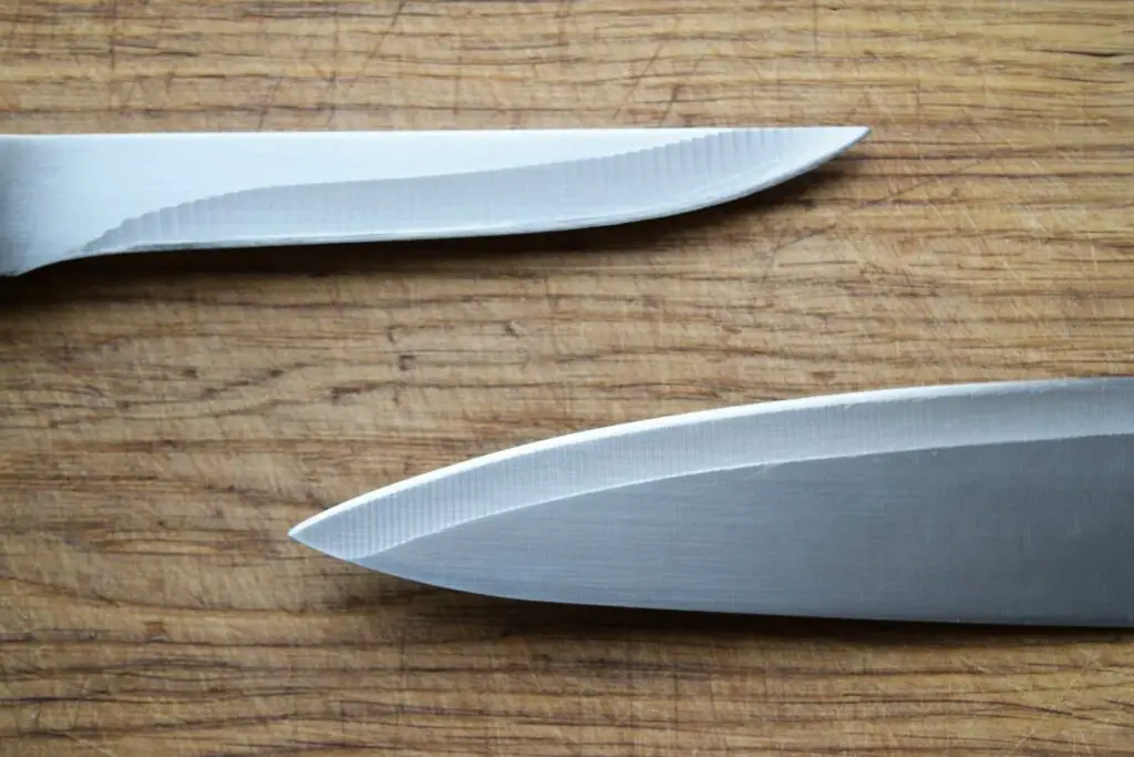 A blade knife and a fillet knife on a wooden table