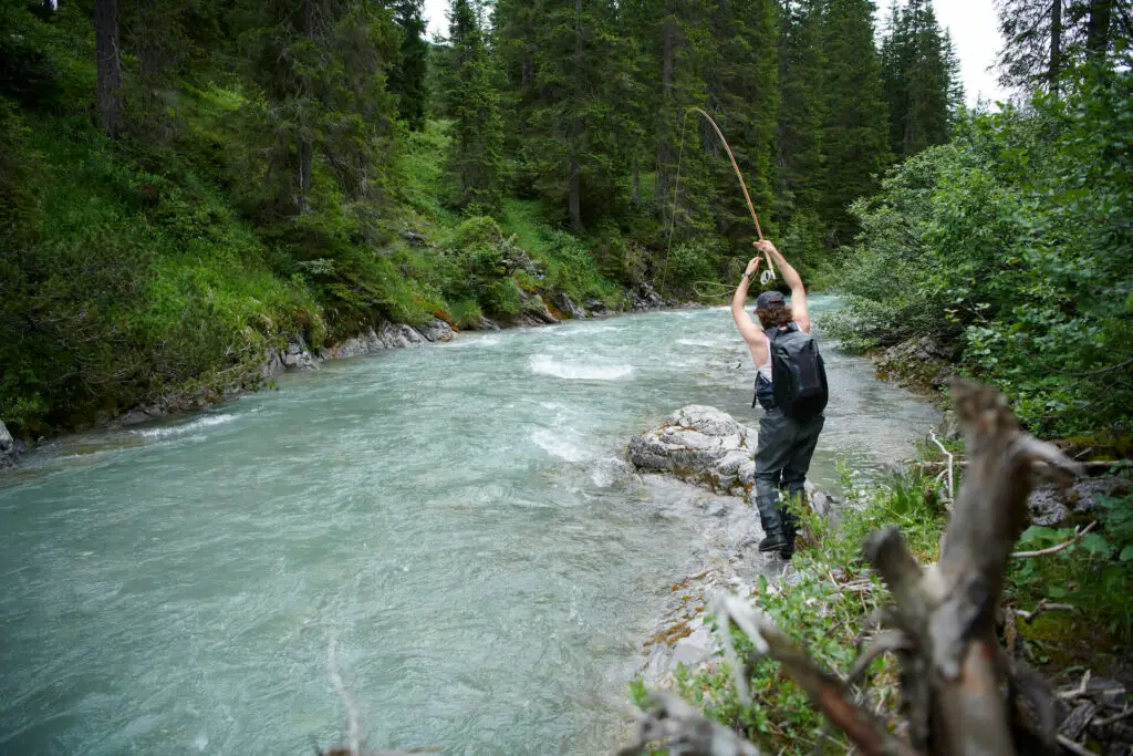 Fly fisherman playing a fish