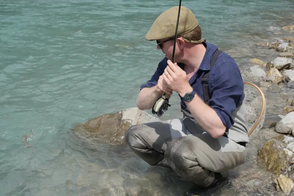 fly fisherman playing a fish