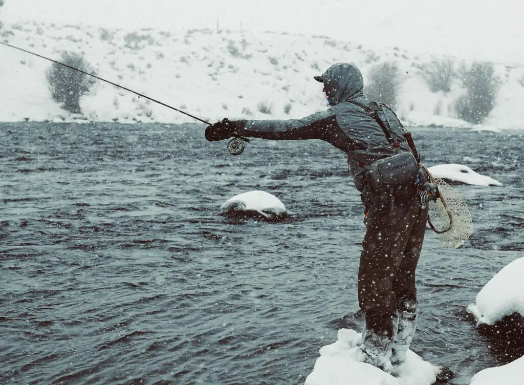 Fly fisherman fishing in the snow