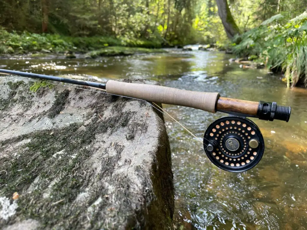 Best Beginner Fly Rod Review: Fly Rod and Reel at a Creek