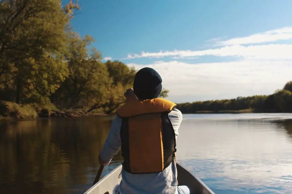 Man in canoe wearing a life vest for fishing