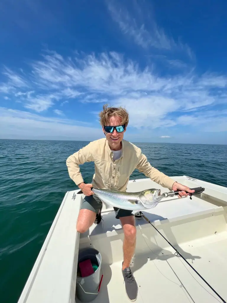 Fly fishermen wearing fishing sunglasses holding a bluefish