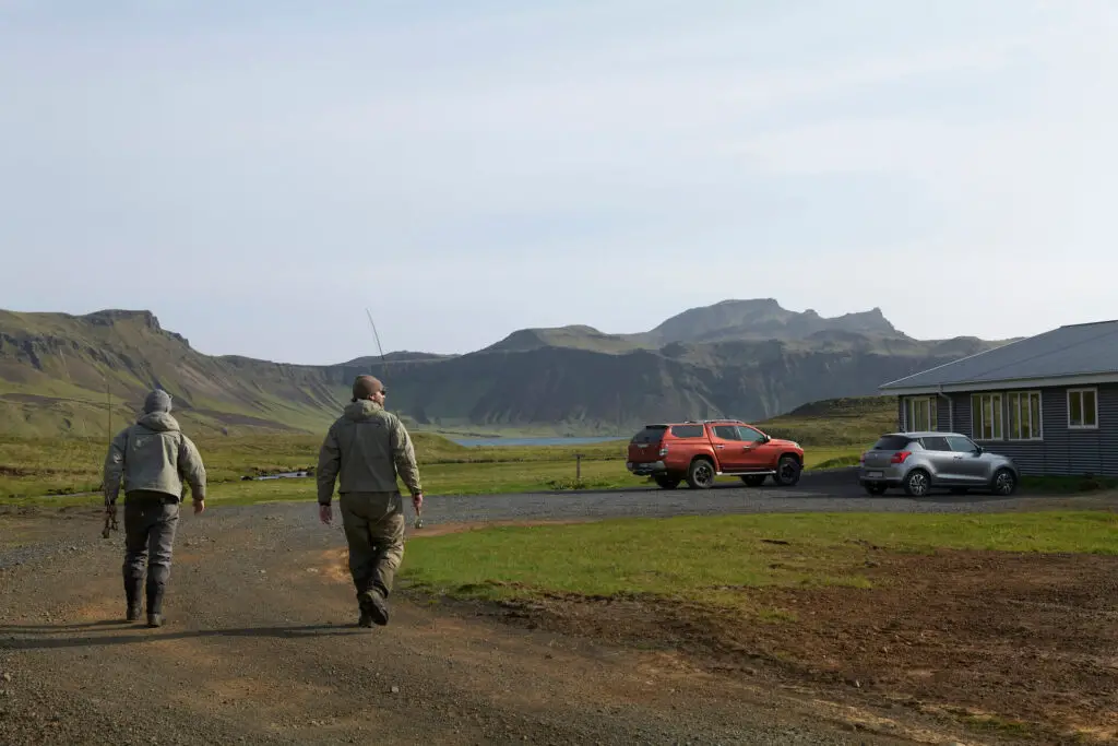 Two fly fishermen walking to a fishing lodge