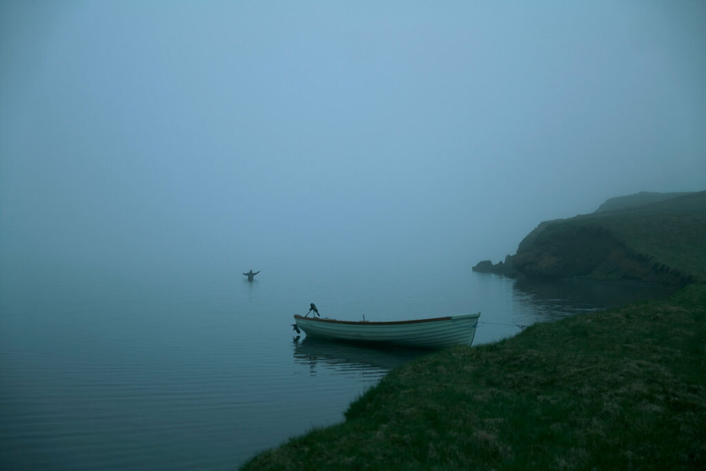 Fly fisherman casting in the fog