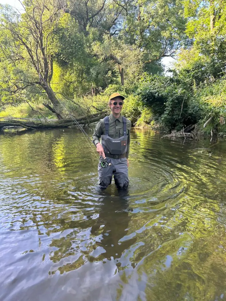 Fly fisherman wading in a river