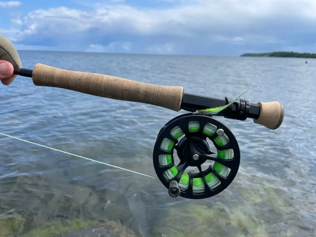 Fly rod and reel in hand of a fly fisherman