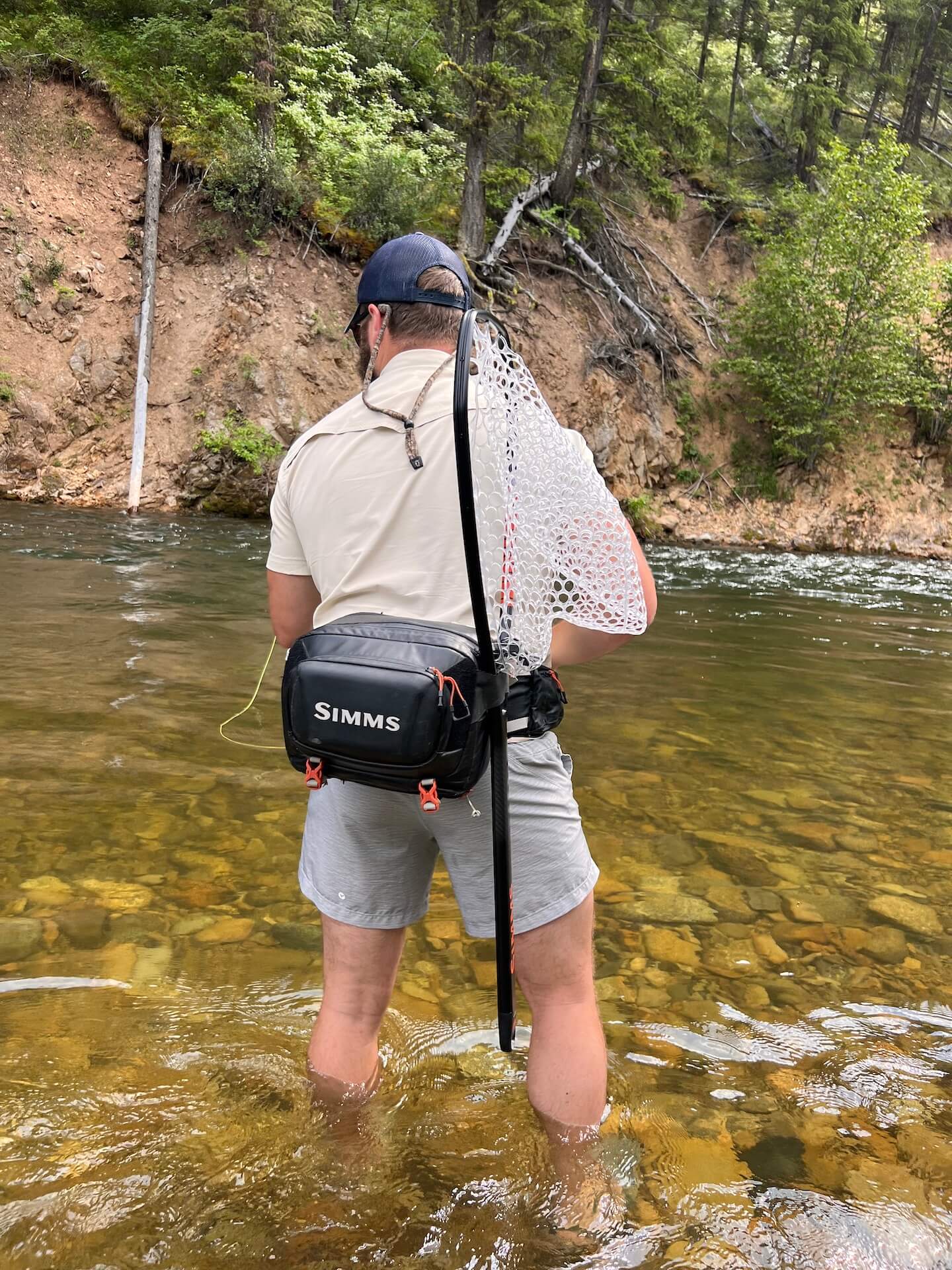 Fly fisherman wet wading a river in Montana