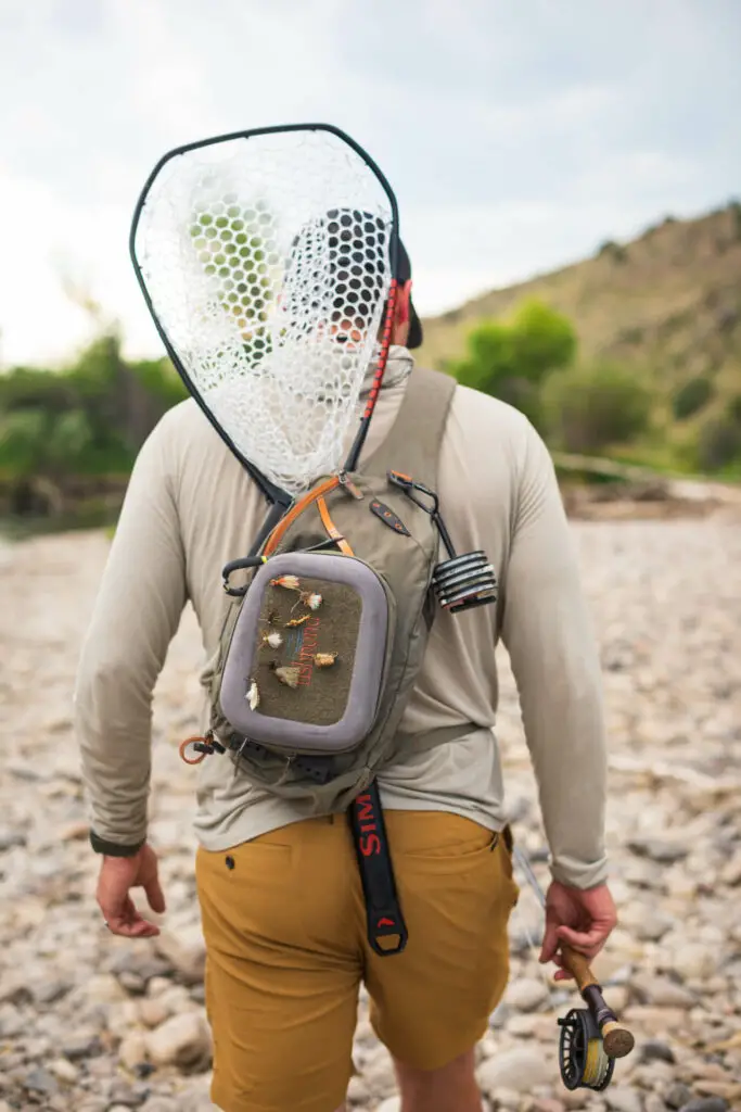 Fly Fisherman carrying a landing net on the back