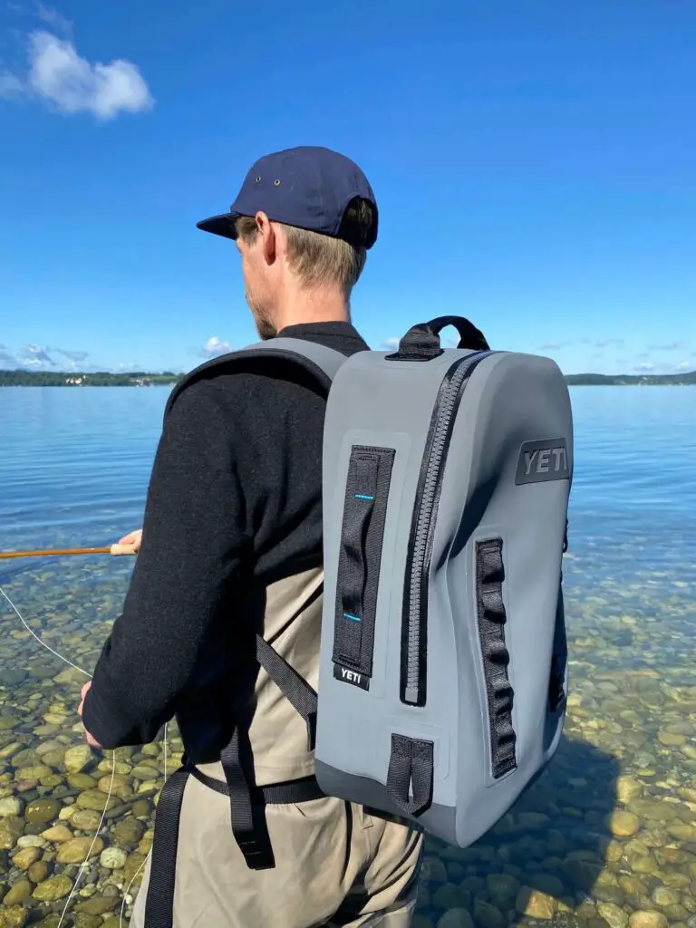 Fly fisherman in the water wearing the YETI Panga 28 Backpack