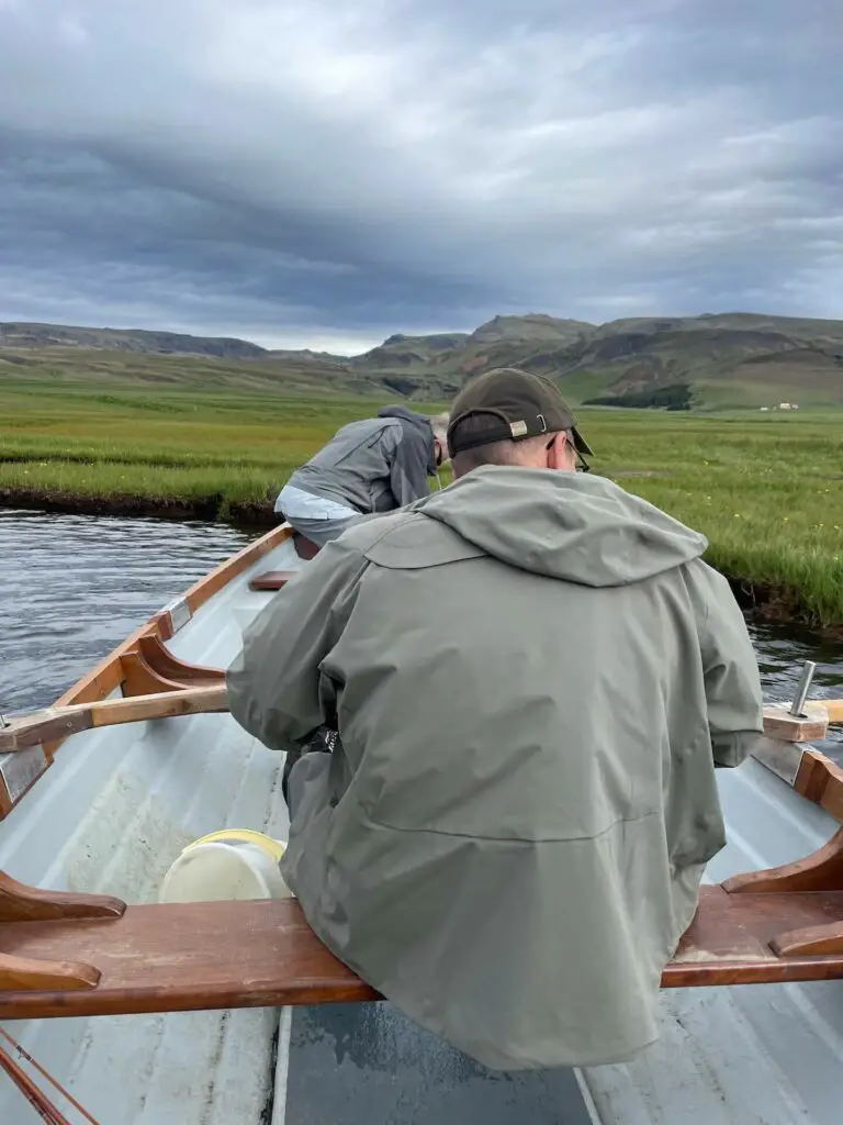 Fly fishermen on a boat wearing wading jackets: premium vs budget wading jackets guide