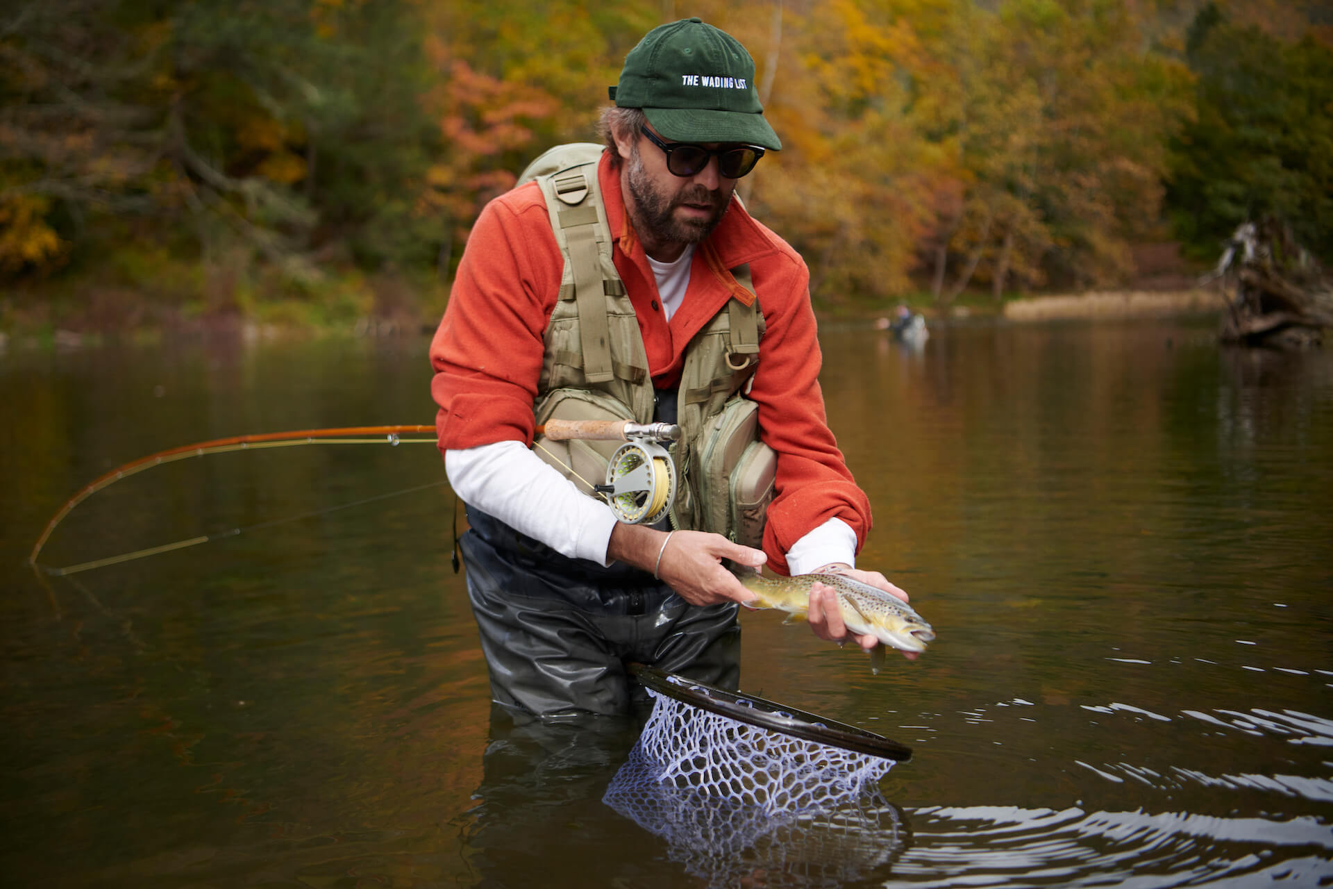 Fly fisherman holding a trout