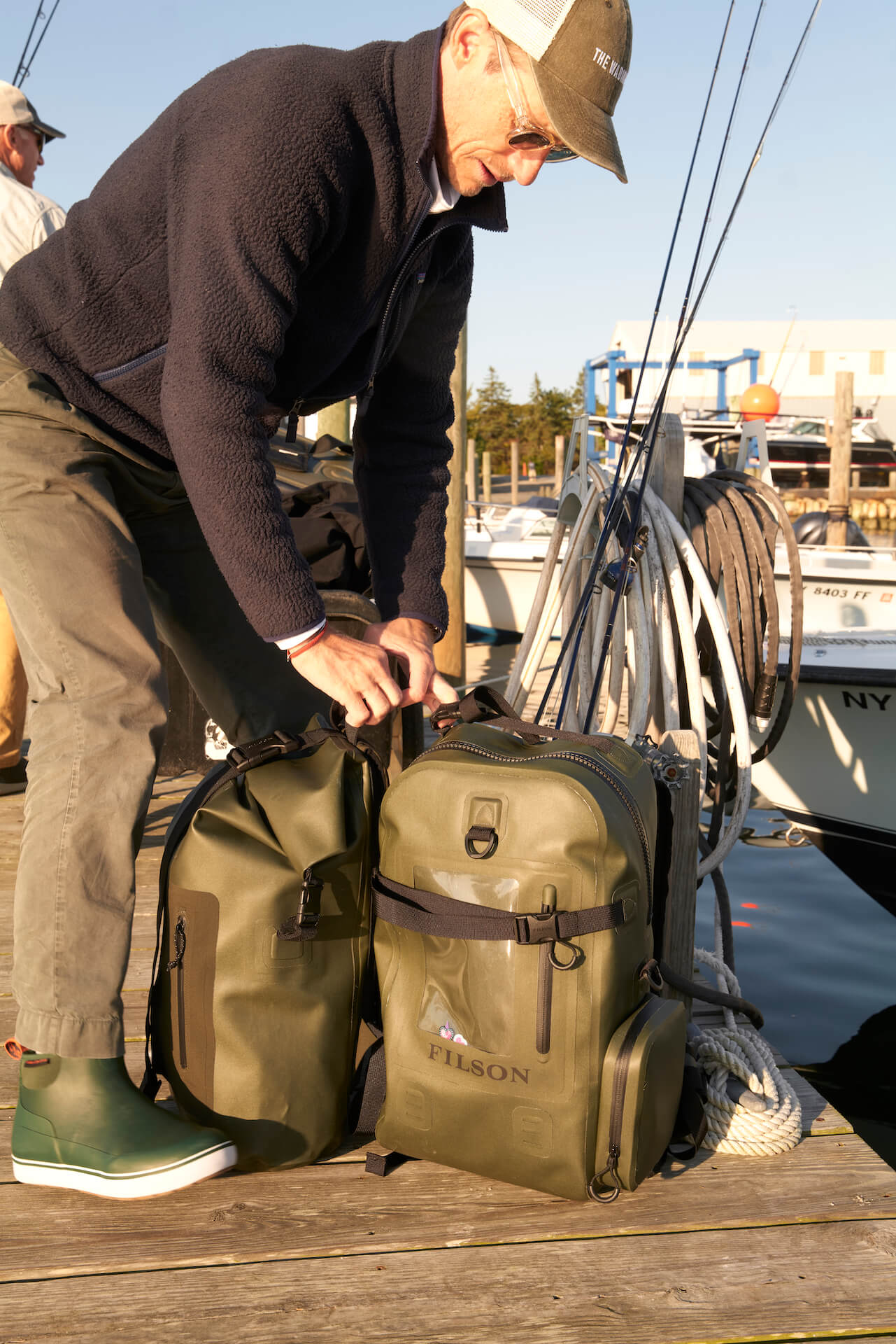 Filson waterproof backpacks for fly fishing on wooden dock