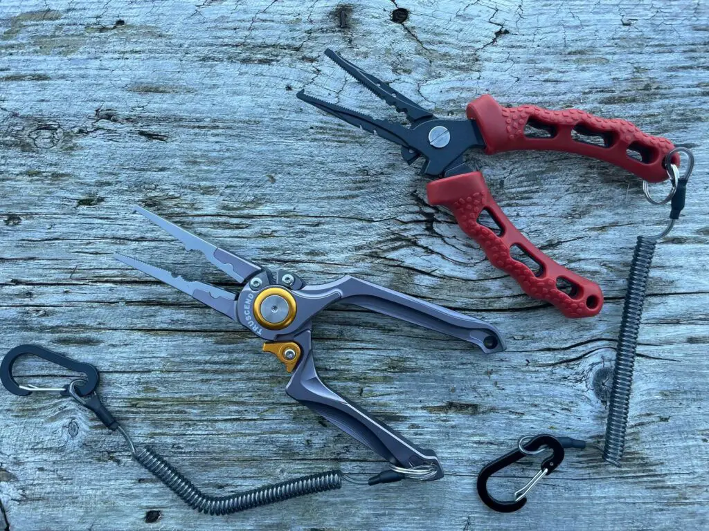 Two pairs of fishing pliers on wooden dock