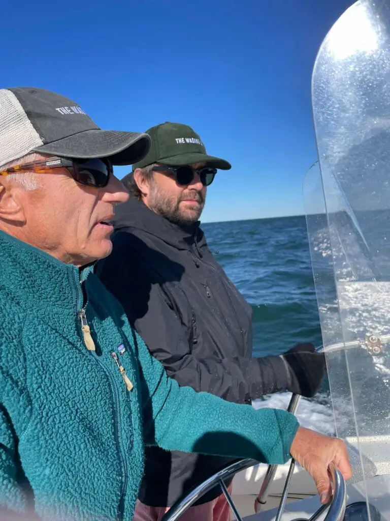 Fly fishermen wearing sunglasses on a boat. Guide on essential fly fishing gear