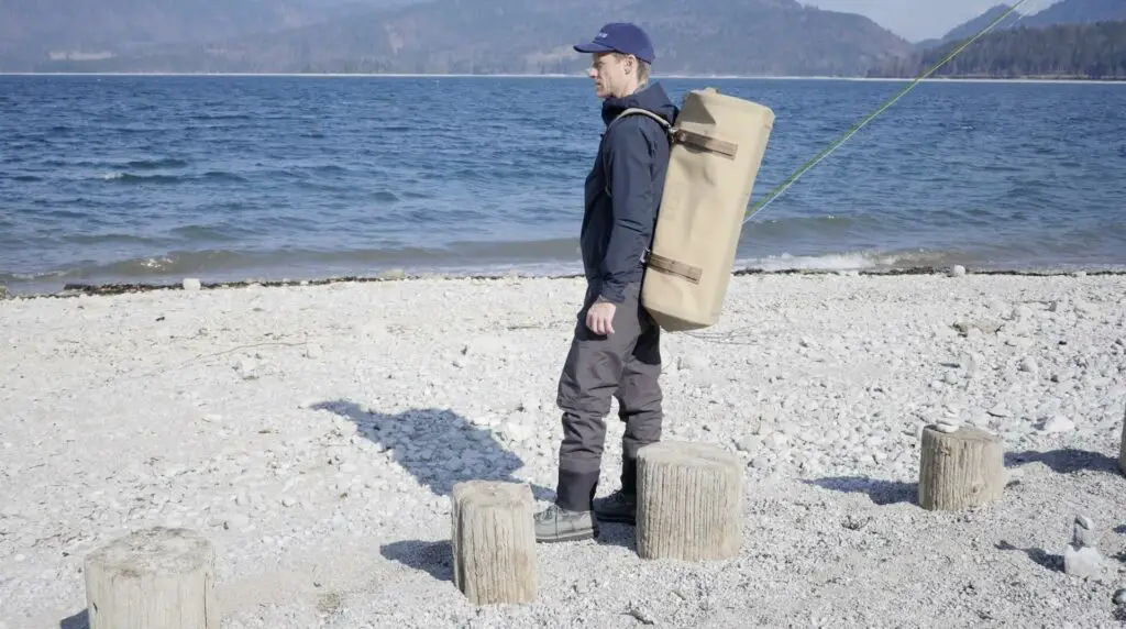 Fly fisherman on the shore with YETI Panga on the back