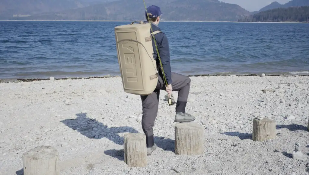 Fly fisherman on the shore with YETI Panga on the back