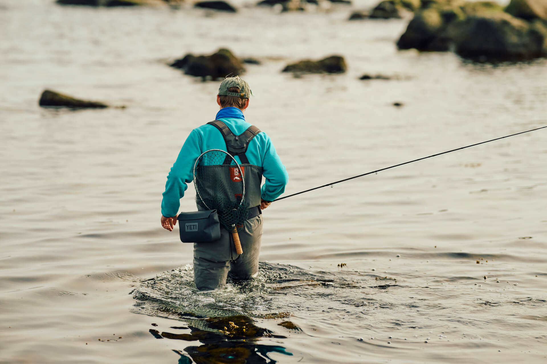 Fly fisherman wading into the sea