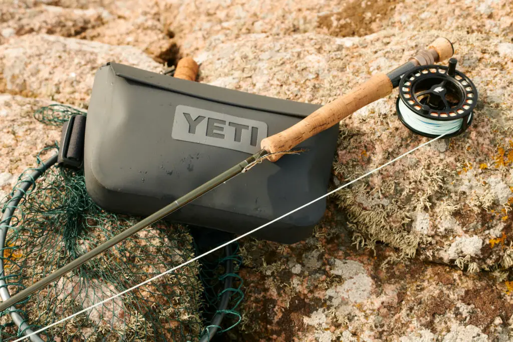 YETI Sidekick on the rocks with fly rod