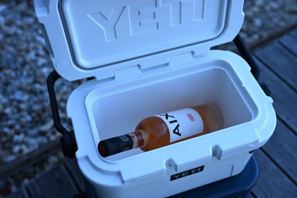 Wine bottle standing beside the shallow YETI Roadie 8 interior