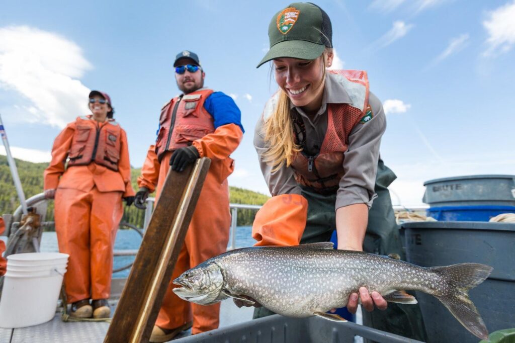 Fishery crew holding an adult invasive lake trout